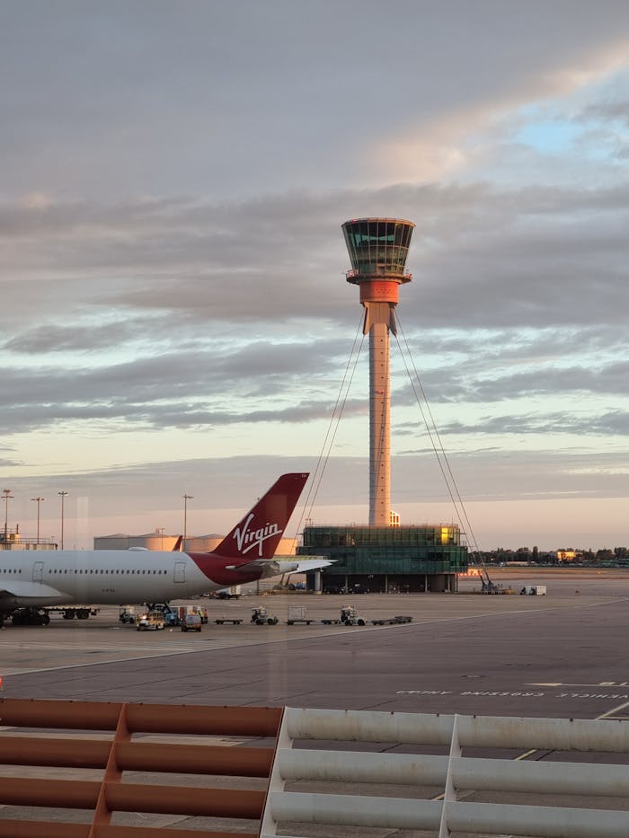 Services The control tower at London Heathrow Airport against a sunset sky, featuring Virgin aircraft.